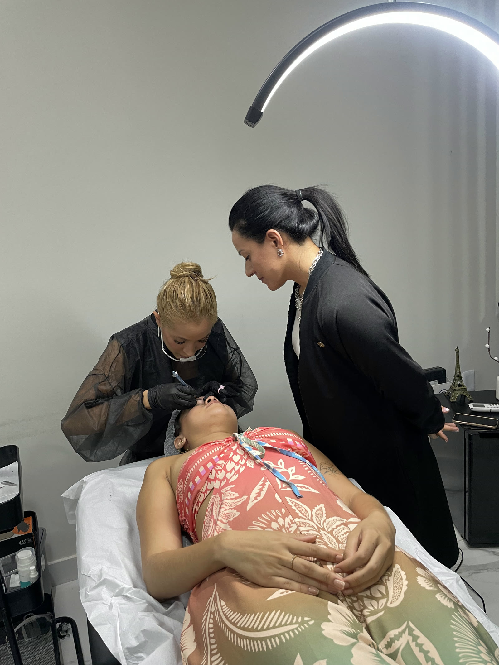 Aluna aplicando a técnica em uma modelo com a Nicole supervisionando